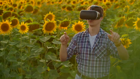 El-Estudiante-Está-Trabajando-Con-Gafas-Vr.-él-Está-Involucrado-En-El-Proceso-De-Trabajo.-Es-Un-Hermoso-Día-Soleado-En-El-Campo-De-Girasoles.