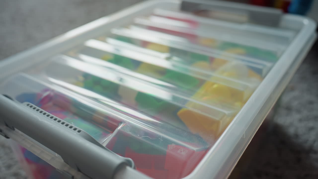 Organisation paisible de la pièce. Espace de vie ordonné, jouets rangés. Chambre propre après le jeu, avec un coffre à jouets fermé. Scène sereine d'une maison bien rangée, jouets sécurisés après les activités.