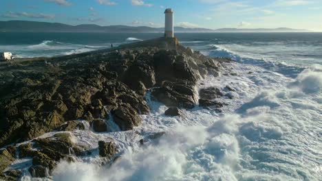 turbulent water crashing on the rocky coast shore of faro de cabo roncudo in corme, coruña, spain