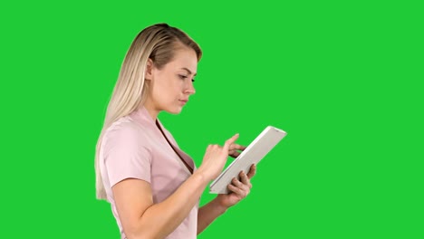 girl holding digital tablet searching for something on a green screen, chroma key