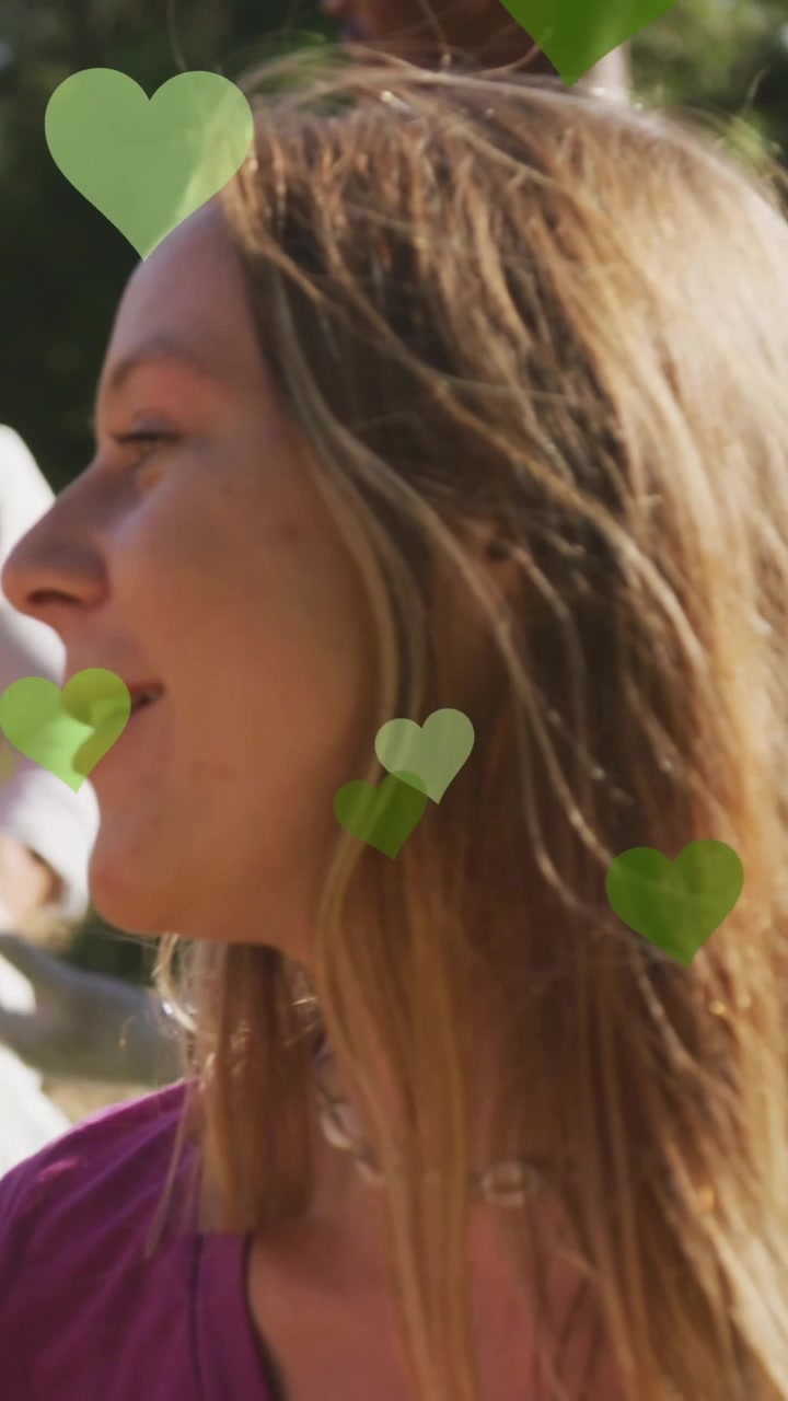 Animazione di cuori verdi su un gruppo felice ed eterogeneo che raccoglie rifiuti in campagna.