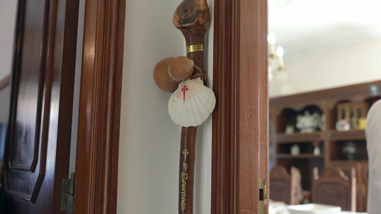 Pilgrim's staff adorned with a scallop shell and St. James cross, symbolizing the spiritual journey of the Camino de Santiago