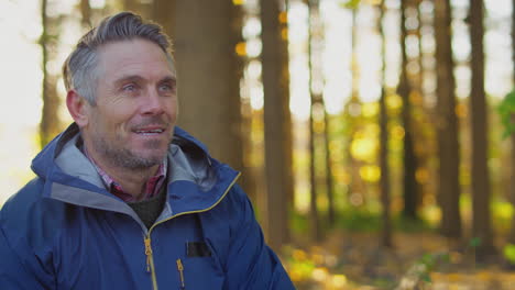 mature man on relaxing walk through fall or winter countryside breathes in deeply - shot in slow motion