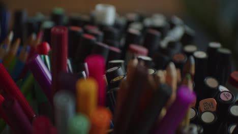 Many-different-colors-of-pencils-and-felt-tip-pen-on-artist-table,-motion-backward