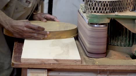 carpenter operates a belt sander to smooth and polish wooden furniture