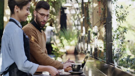 a young man getting served coffee while using