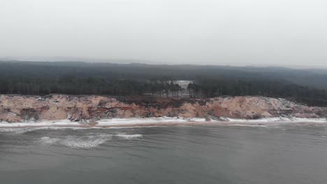 toma aérea de olas rompiendo en la playa de arena de ustka en invierno