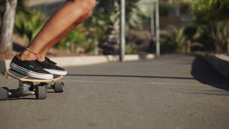 the summer setting comes alive in slow motion, featuring a young woman riding a longboard near palm trees, sporting shorts and sneakers