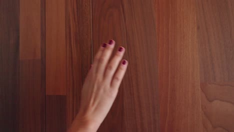 woman runs her hand along wooden wall and opens a bathroom door