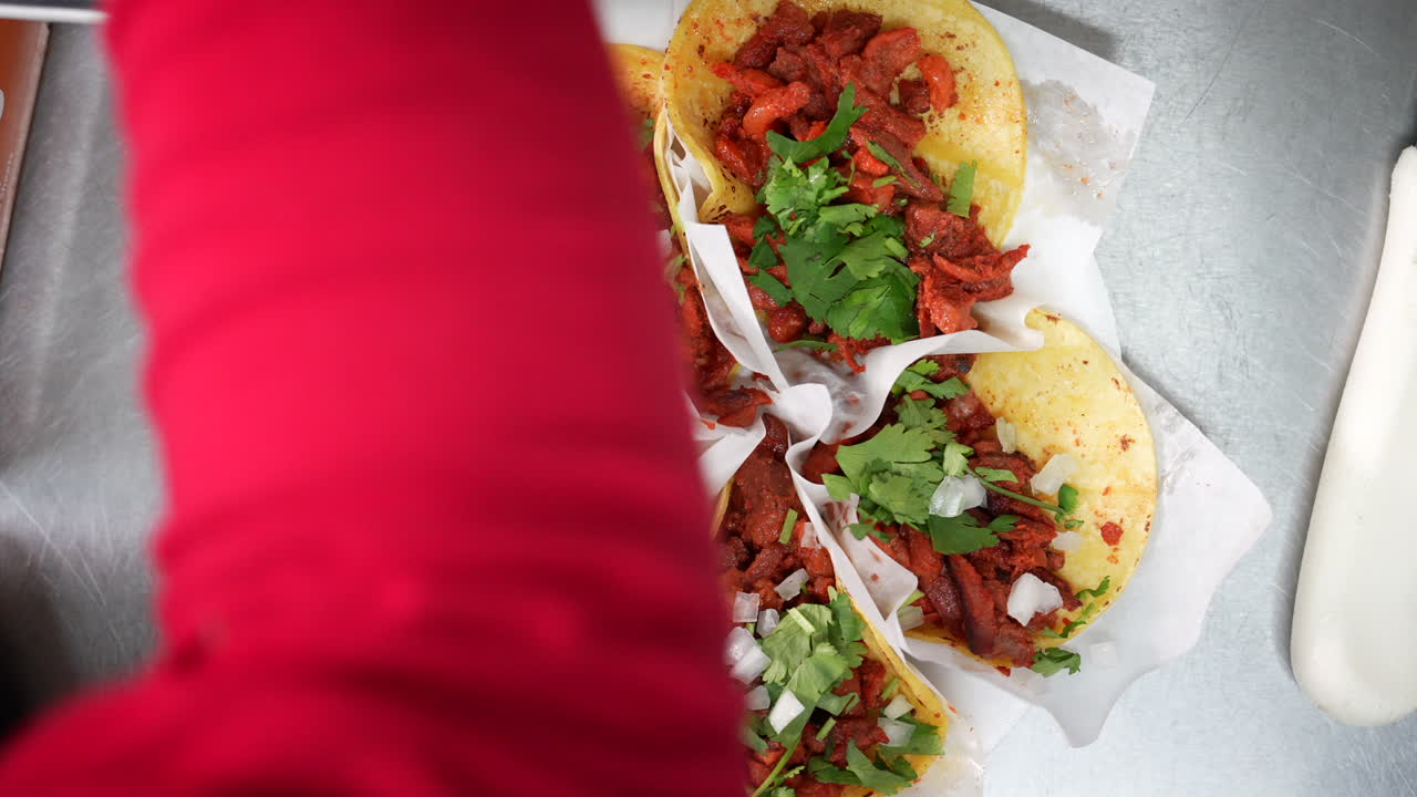 espolvorear cebollas picadas en un plato de tacos callejeros - serie de camiones de comida