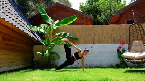 the girl doing yoga with a headstand on the grass wellness