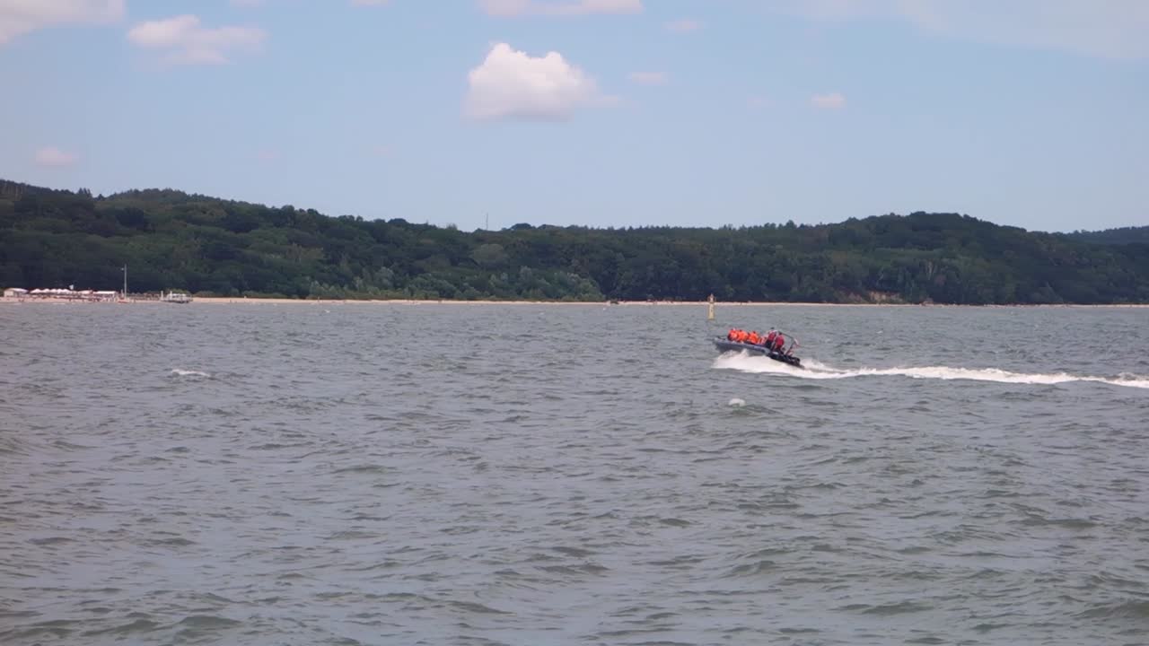 катер с туристами в оранжевых спасательных жилетах на море в сопоте, польша