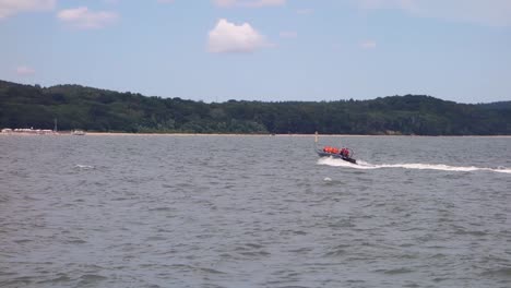 lancha rápida con turistas en chalecos salvavidas naranjas en el mar en sopot, polonia
