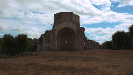 Abbazia-di-San-Bruzio,-a-damaged-ruin-of-an-abandoned-old-medieval-monastery-abbey-church-in-Tuscany-from-the-11th-century-surrounded-by-olive-trees-in-Italy