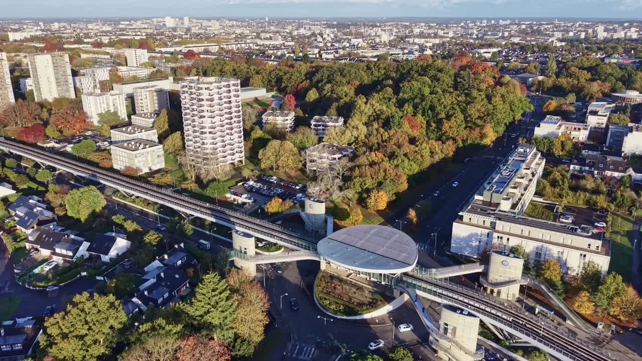 Lotnicze ujęcie z drona nowoczesnej stacji metra La Poterie w Rennes. Ujęcie ogólne przedstawiające wyjątkową architekturę otoczoną kolorowymi jesiennymi drzewami. Idealne do koncepcji transportu miejskiego, Francja