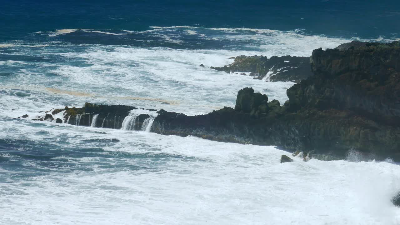 강력한 파도가 바위가 있는 해안선에 부히고