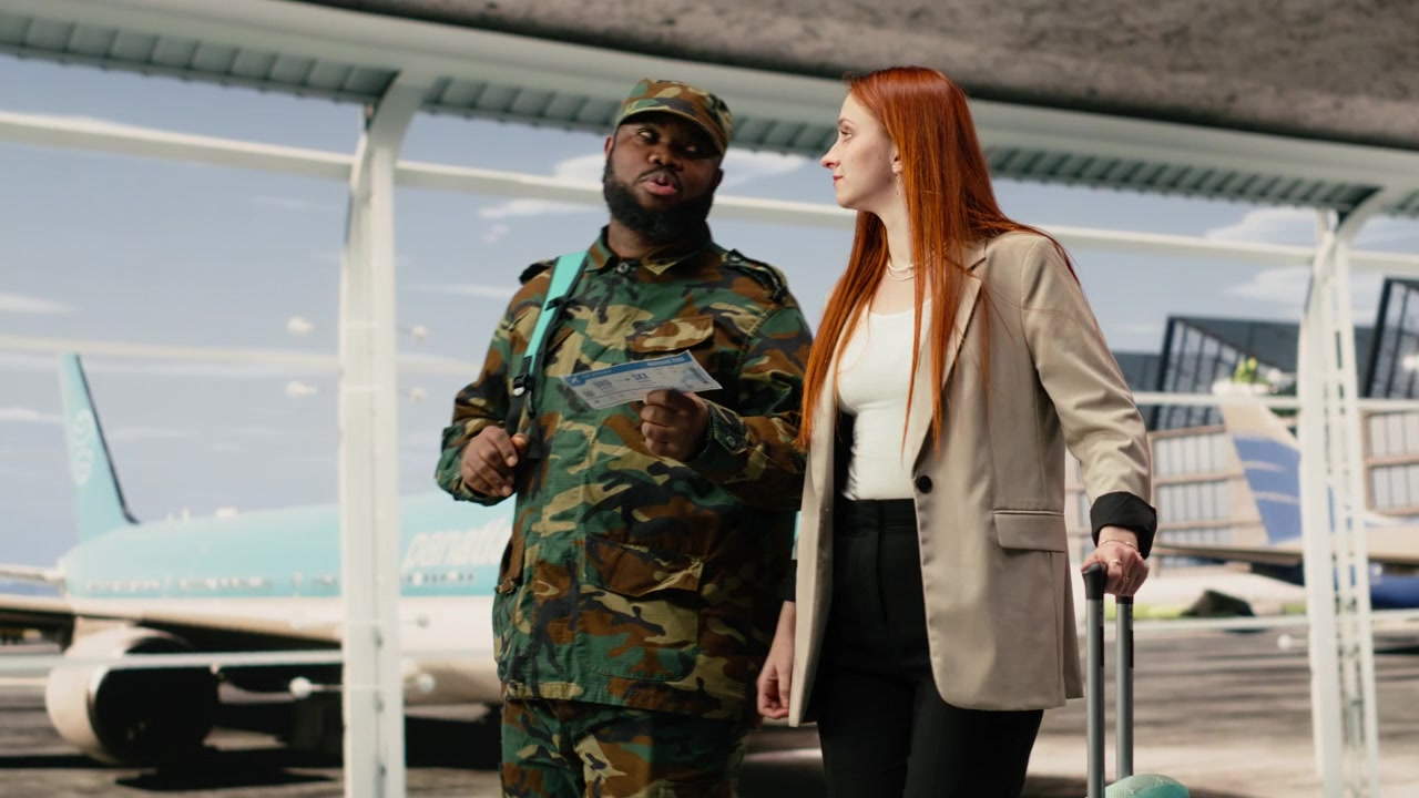 Soldato dell'esercito in aeroporto che parla con una donna della carta d'imbarco.