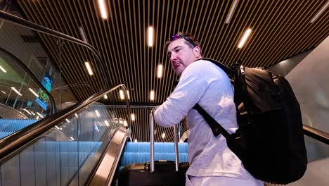 man with luggage on escalator in turin station