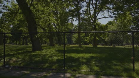 Panning-shot-of-fence-with-Lake-View-Cemetery-in-the-background-on-a-sunny-summer-day