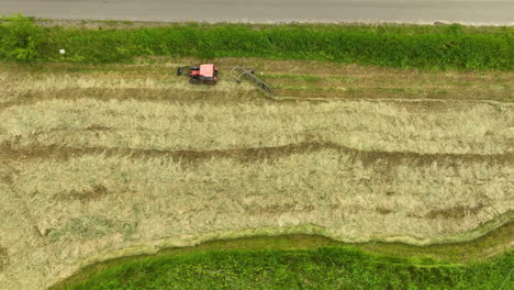 Vista-Aérea-De-Un-Tractor-Cosechando-Un-Campo-Con-Ordenadas-Hileras-De-Cultivos