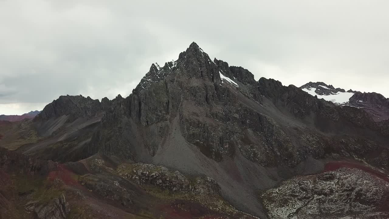 Aerial, pan, drone shot of peaks, on a dark, cloudy day, in Peru, Andean mountains, South America