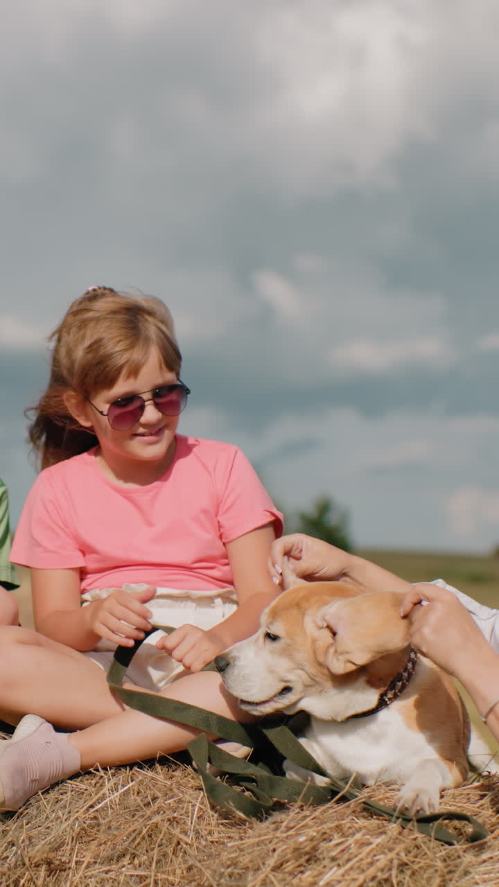 웃는 가족은 시골을 즐기고 할머니는 개 귀를 놀이롭게 펴고, 아이들은 풀에서 휴식을 취하고, 바구니를 들고 있는 여자가 웃고, 에 빛나는 풀과 푸른 하늘이 있습니다.