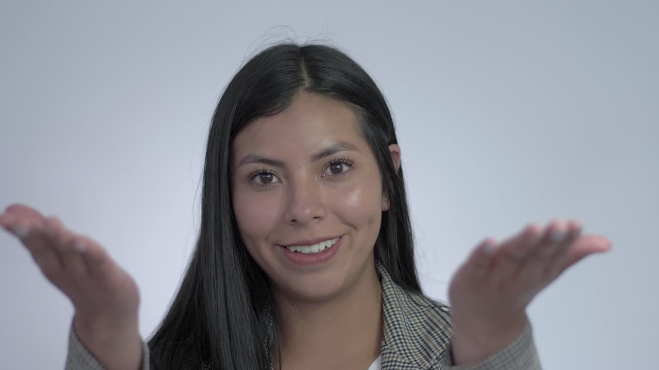 la chica sonriente lleva las manos a la boca y sopla un beso hacia la lente, enviando amor y afecto en un gesto dulce y tierno