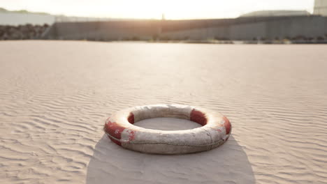 lonely life buoy on a sandy beach at sunset