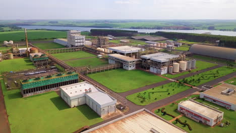 Gigantic-installation-of-an-industry-in-the-rural-area,-in-the-background-we-can-see-a-lot-of-green-vegetation-and-a-beautiful-river