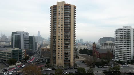 Aerial-drone-view-rising-in-front-of-a-apartment-building,-in-cloudy-San-Francisco,-USA