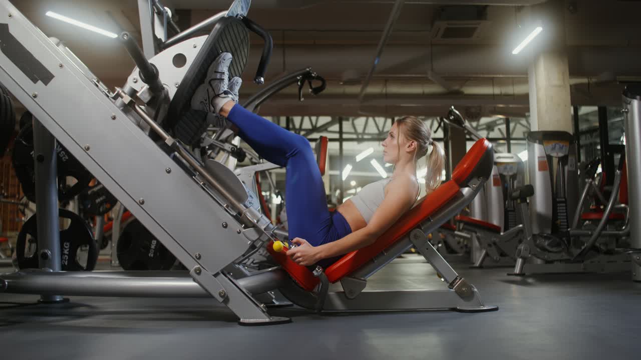 Woman Doing Leg Press Exercise in Gym