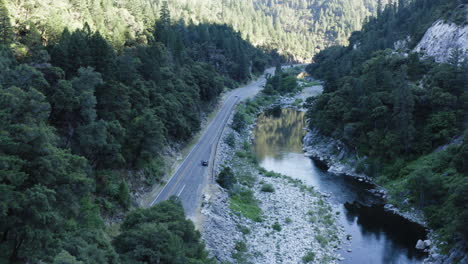 increíble cañón con río tranquilo y exuberante bosque que cubre la ladera de la montaña, aéreo