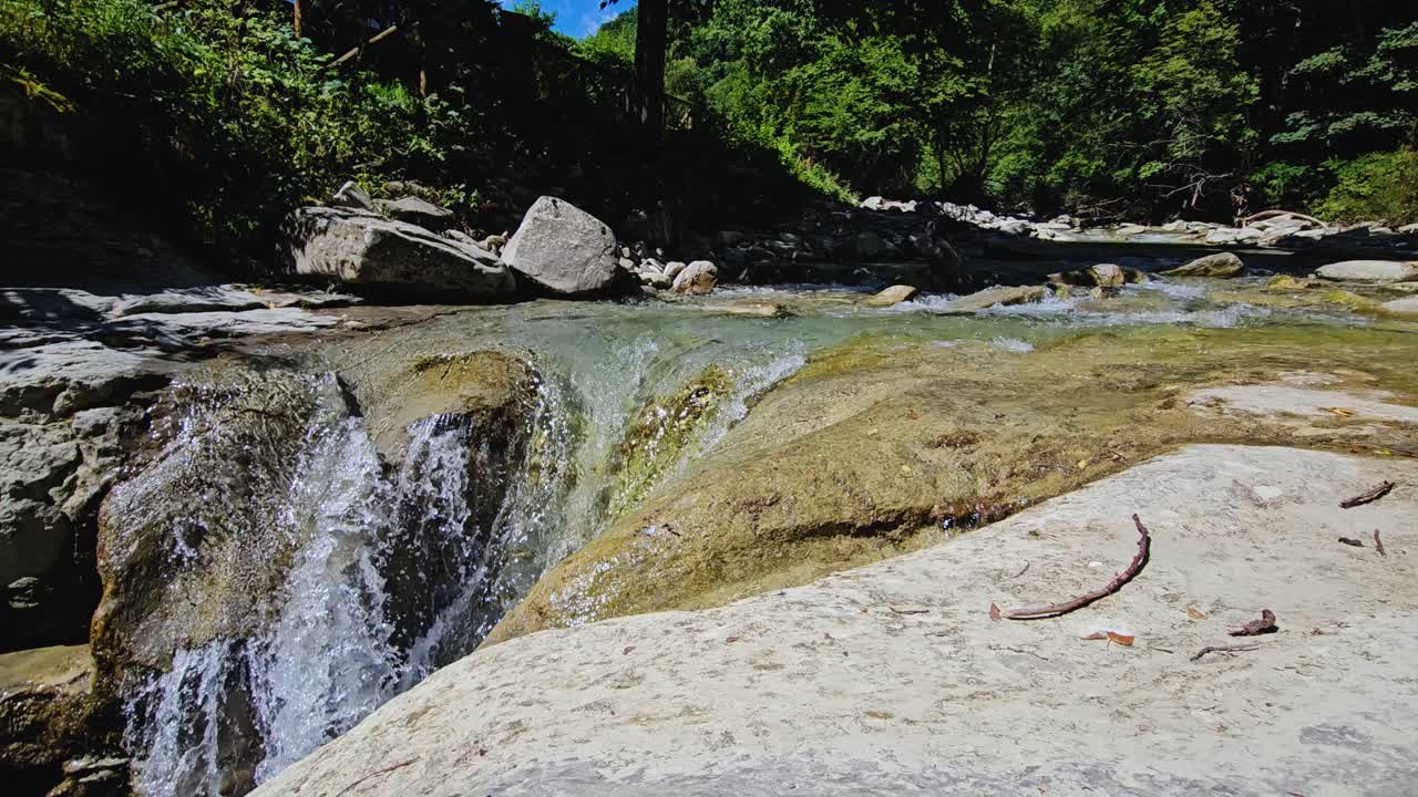 una serena cascada cae en un pintoresco cañón italiano rodeado de exuberante vegetación