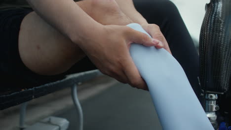 runner with amputated leg putting on prosthetic sock