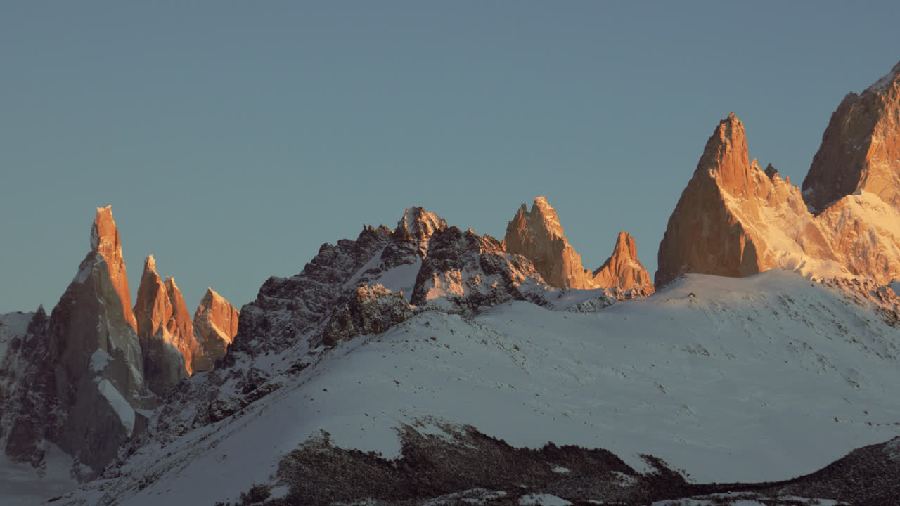 파타고니아 안데스 산맥의 눈 인 세로 토레 (cerro torre) 와 피츠 로이 (fitzroy) 정상 위에서 장엄한 해가 뜨는 모습