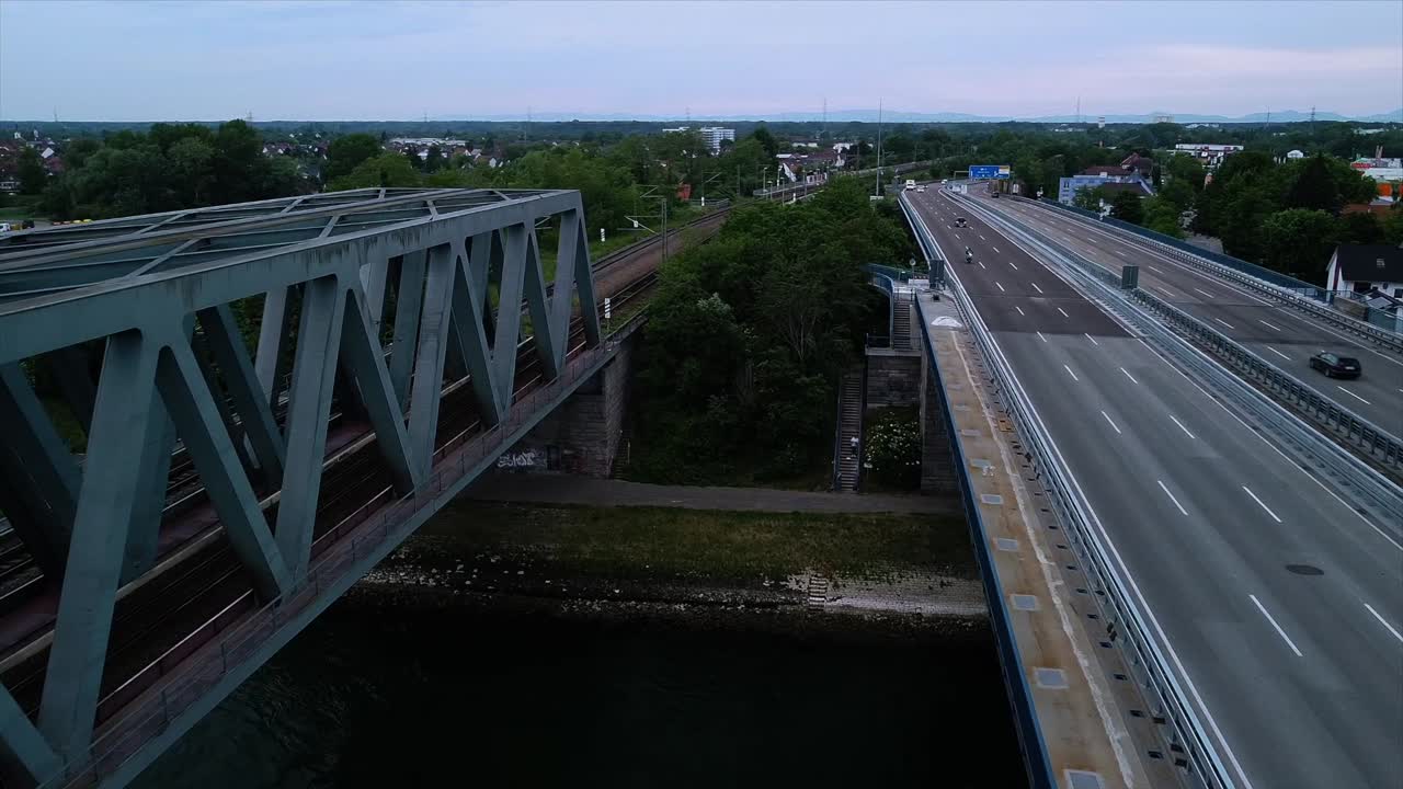 Drone flying between a railroad and an automobile bridge in central Europe spanning over the Rhine Rhiver