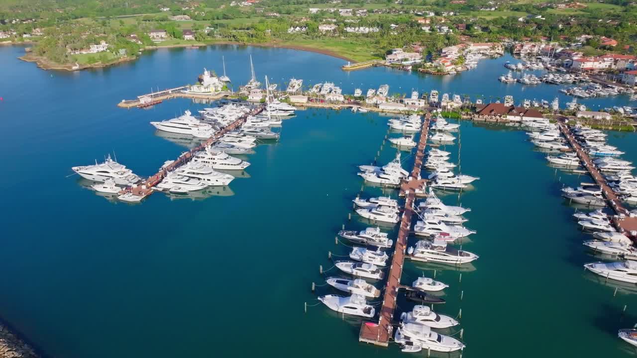 Flygvy över lugna Casa de Campo Marina med många förtöjda yachter.