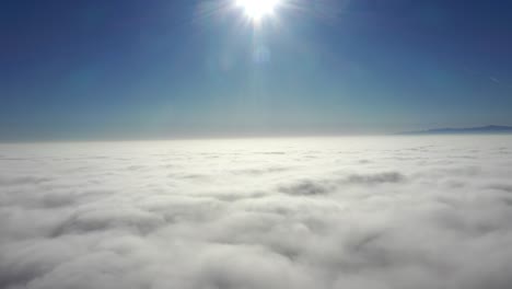 scenic view above bed of white fluffy clouds under bright sunlight