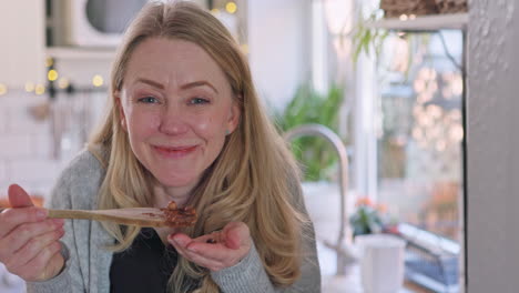 mujer degustando comida en la cocina