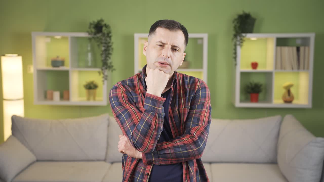 el hombre está pensando en un plan serio en casa, resolviendo el problema en su mente y asintiendo con la cabeza en acuerdo.