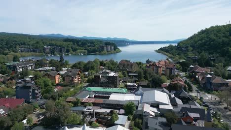 panoramic drone view of pucon's lakeside skyline, showing urban buildings and villarrica lake under a clear sky