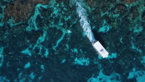 Vista-única-De-Un-Barco-De-Buceo-Mientras-Se-Mueve-A-Través-Del-Agua-Sobre-Un-Sistema-De-Arrecifes-Tropicales