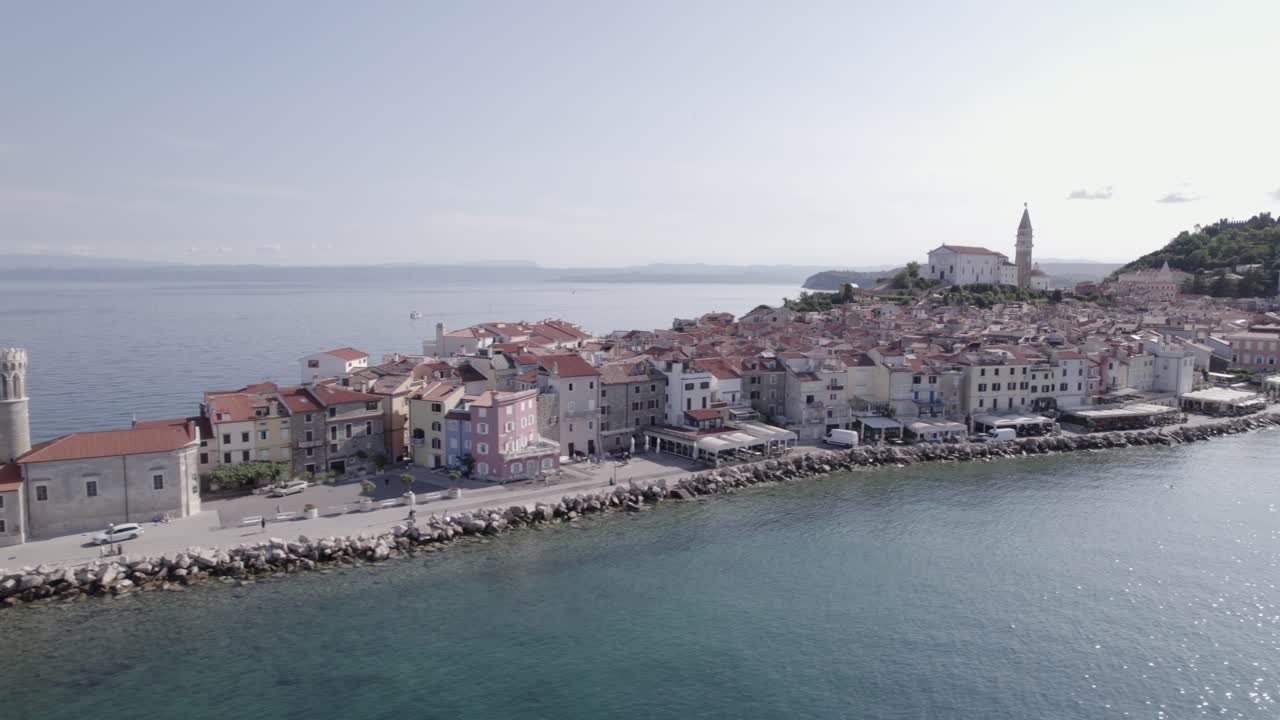 Drone video of side shot "slider" of the city of Piran in Slovenia, starting at the Lighthouse to the right discovering the city and the church