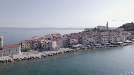 video de drone de toma lateral "slider" de la ciudad de piran en eslovenia, comenzando en el faro a la derecha descubriendo la ciudad y la iglesia
