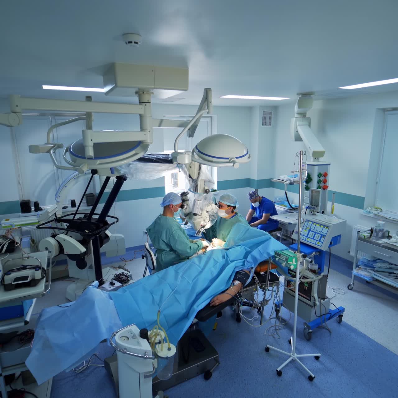 Technologically equipped surgery room in modern hospital. Neurosurgical operation taking place in the operational theatre. Approaching surgeons busy at work
