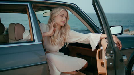 woman in vintage car by the beach