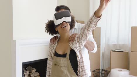 happy young couple doing virtual tour in new apartment