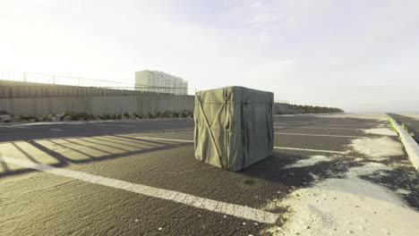 mysterious wrapped package sits alone on empty street near the beach