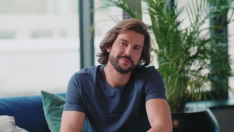 retrato de un hombre guapo sentado en el sofá en la sala de estar