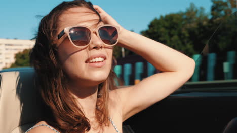 mujer feliz conduciendo un descapotable